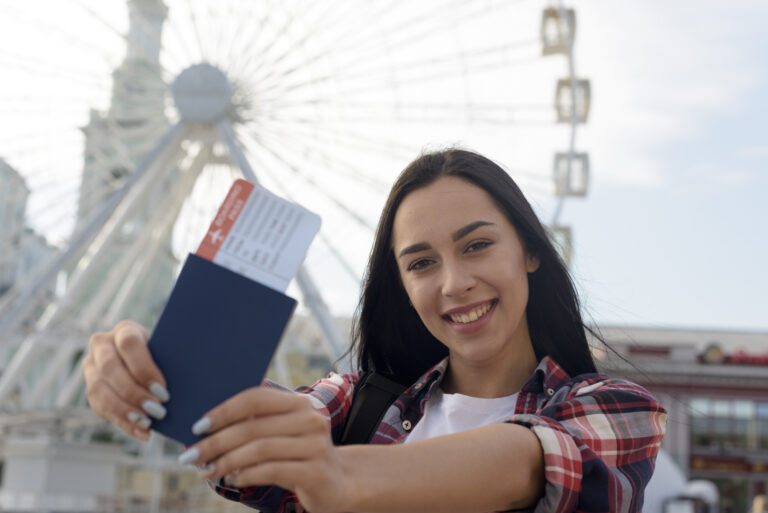 portrait-smiling-woman-showing-air-ticket-passport