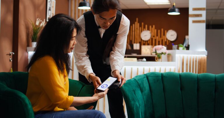 Tourist using nfc payment to buy coffee cup from hotel bar